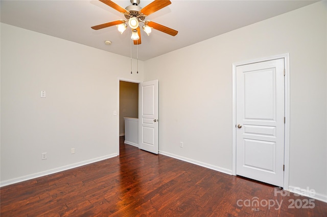 spare room with dark wood-type flooring and ceiling fan