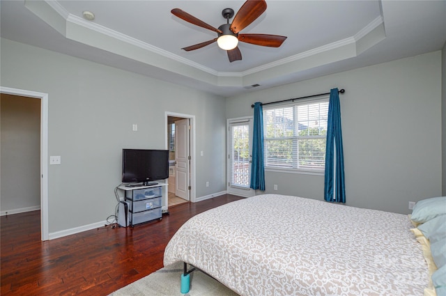 bedroom featuring dark wood-type flooring, ornamental molding, a raised ceiling, and ceiling fan