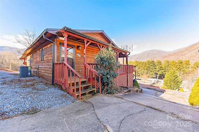 view of side of property with a mountain view and cooling unit