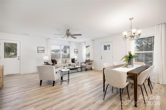 dining space featuring ceiling fan with notable chandelier and light wood-type flooring