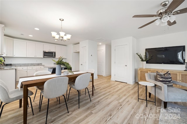 dining room featuring ceiling fan with notable chandelier and light wood-type flooring