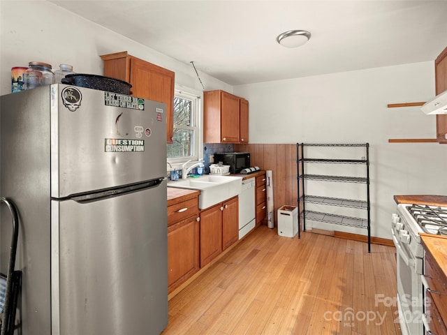 kitchen with sink, white appliances, and light wood-type flooring