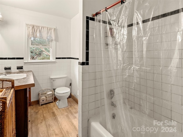 full bathroom featuring shower / bath combo, wood-type flooring, toilet, vanity, and tile walls