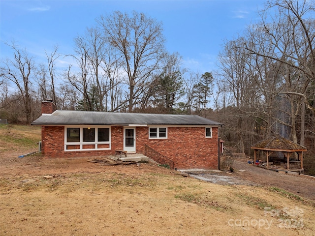 back of property featuring a gazebo