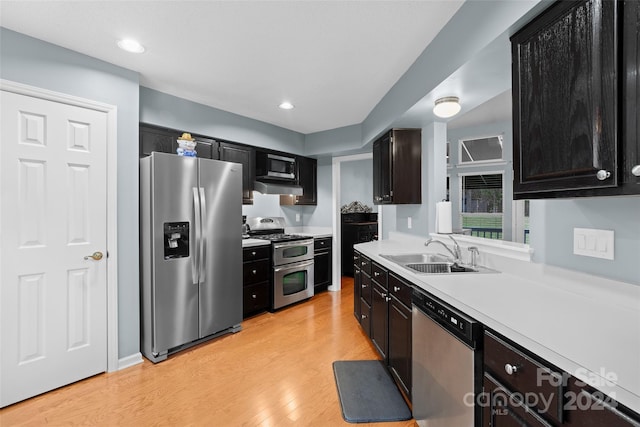 kitchen with stainless steel appliances, light hardwood / wood-style flooring, and sink