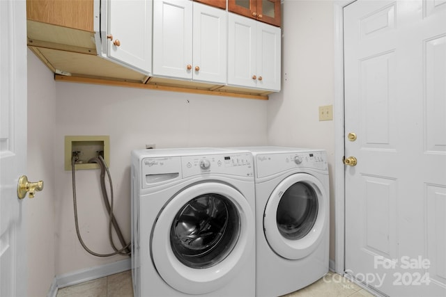 laundry room with light tile patterned floors, cabinets, and independent washer and dryer