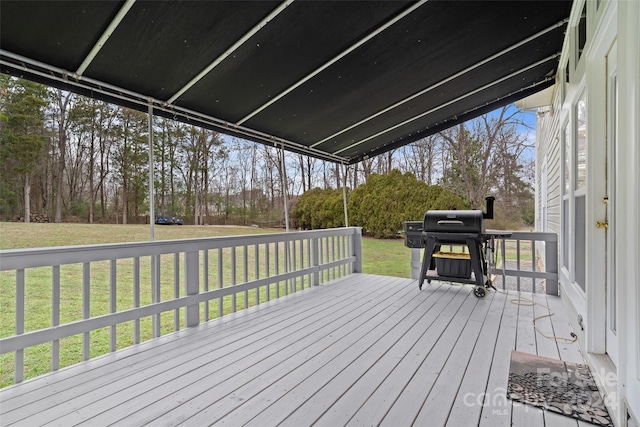 wooden deck featuring a yard and a grill