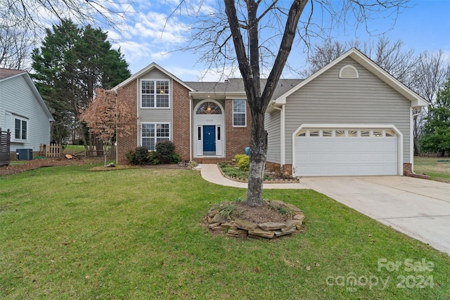 view of front of home with central air condition unit, a front yard, and a garage