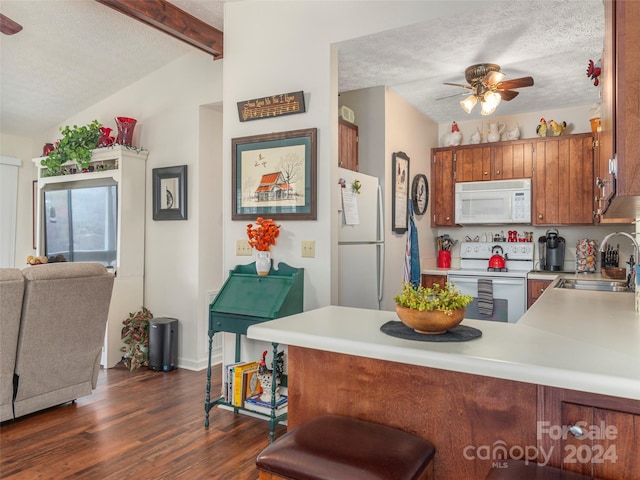 kitchen featuring white appliances, sink, a textured ceiling, dark hardwood / wood-style flooring, and kitchen peninsula