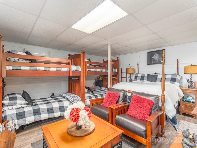 bedroom with a paneled ceiling and light hardwood / wood-style floors