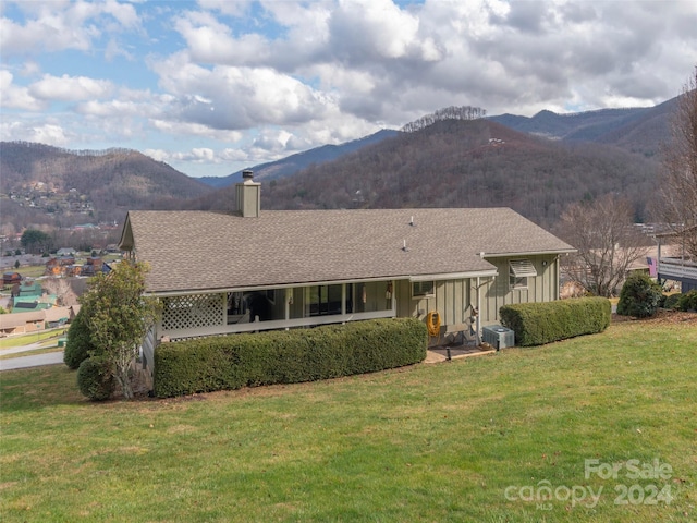 exterior space with a lawn, central AC, and a mountain view