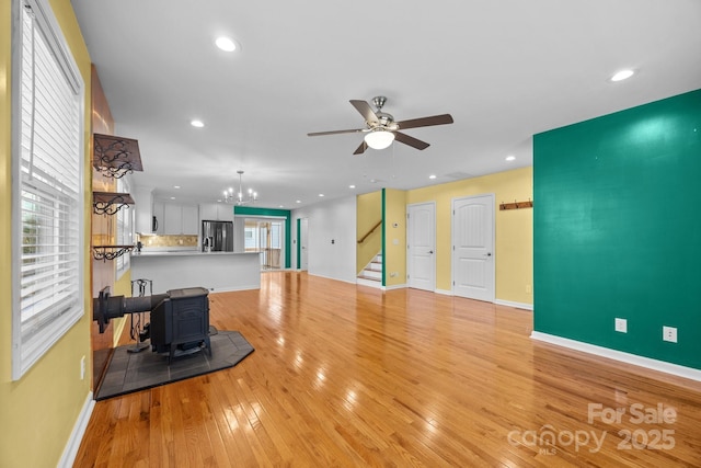 113 Burton St, Asheville, NC 28806 - living area featuring stairs, ceiling fan with notable chandelier, light wood-style floors, a wood stove, and baseboards