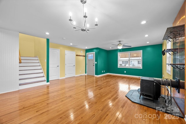 113 Burton St, Asheville, NC 28806 - unfurnished living room with hardwood / wood-style flooring, a wood stove, stairs, and ceiling fan with notable chandelier