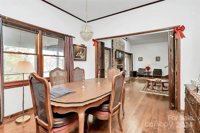 dining room featuring hardwood / wood-style floors, a notable chandelier, and lofted ceiling