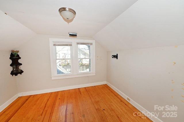 additional living space featuring wood-type flooring and lofted ceiling