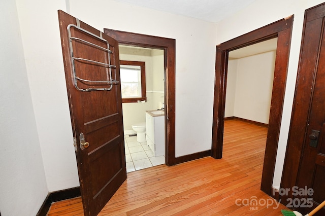 hallway with light hardwood / wood-style floors