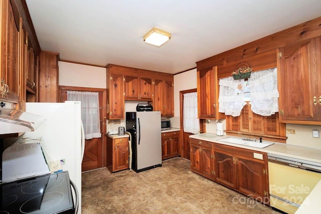 kitchen with dishwasher, range, white refrigerator, and sink