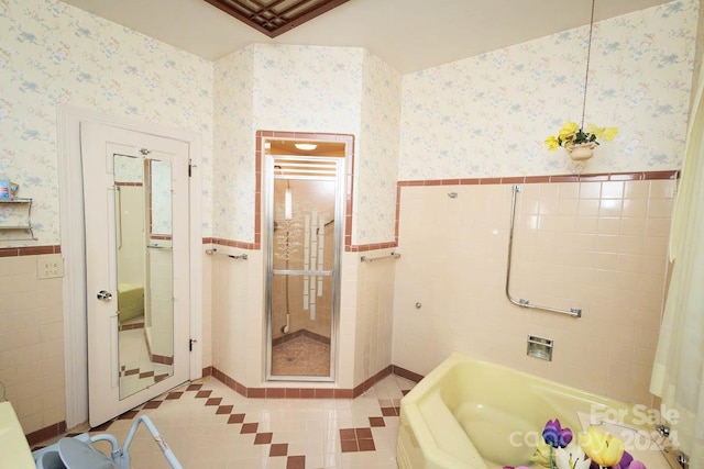 bathroom with tile patterned floors, separate shower and tub, and tile walls