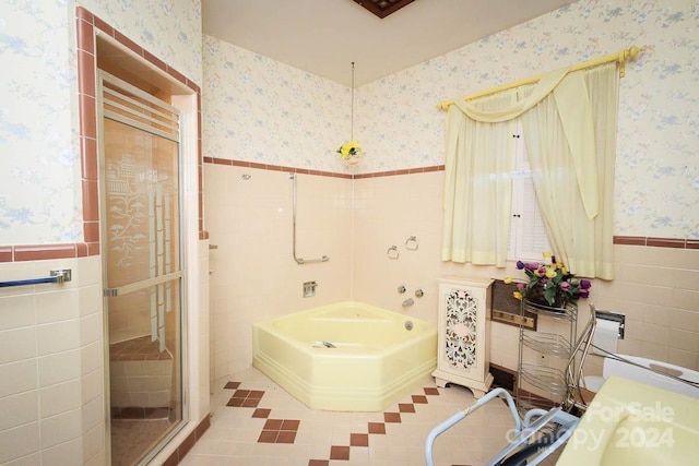 bathroom with radiator heating unit, plus walk in shower, and tile walls