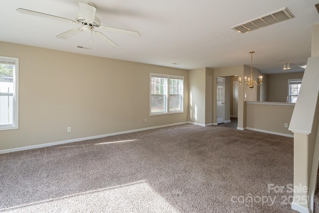 unfurnished living room featuring carpet flooring and ceiling fan with notable chandelier