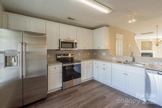 kitchen with white cabinets, decorative light fixtures, sink, and stainless steel appliances