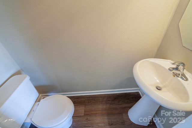 bathroom with wood-type flooring and toilet