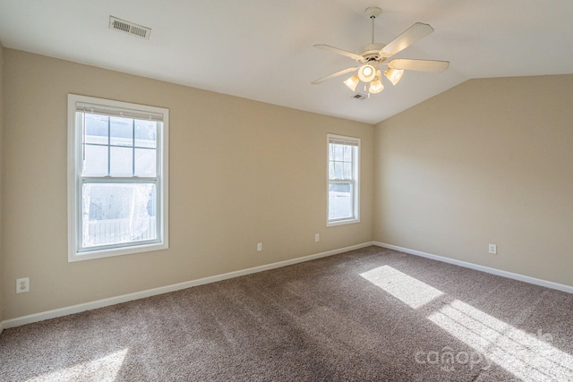 carpeted spare room featuring ceiling fan, plenty of natural light, and lofted ceiling