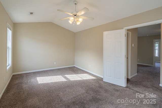 carpeted spare room featuring ceiling fan, a healthy amount of sunlight, and lofted ceiling