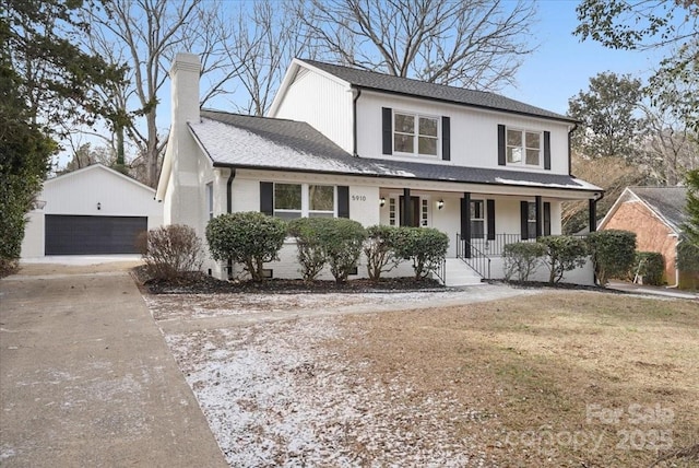 front of property featuring an outbuilding, a garage, a front lawn, and covered porch