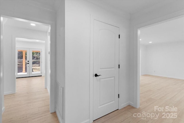 hall with french doors and light hardwood / wood-style flooring