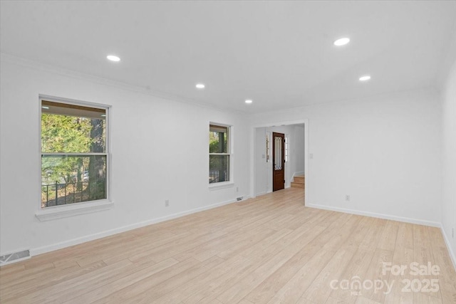 empty room featuring ornamental molding and light hardwood / wood-style floors