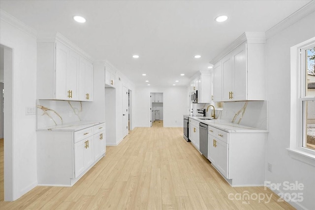 kitchen with light stone counters, stainless steel appliances, backsplash, and white cabinets