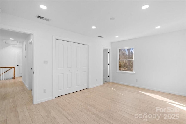 unfurnished bedroom with a closet and light wood-type flooring