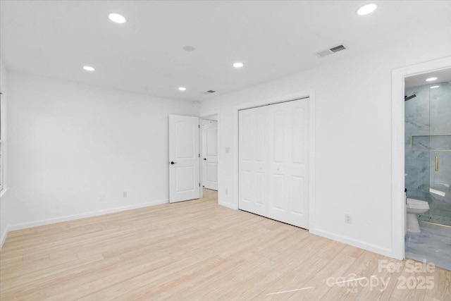 unfurnished bedroom with light hardwood / wood-style floors, a closet, and ensuite bathroom