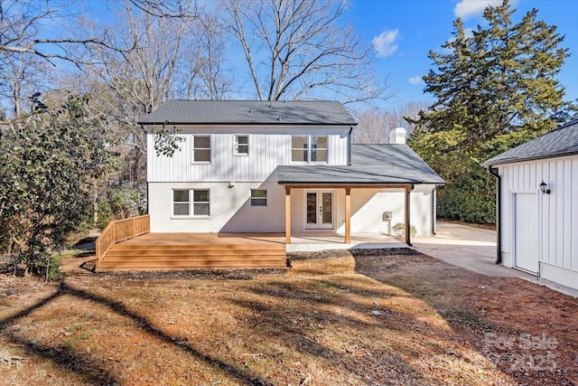 back of property with french doors, a wooden deck, and a patio area