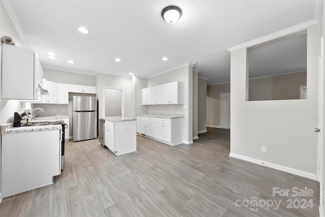 kitchen with ornamental molding, white stove, a center island, white cabinetry, and stainless steel refrigerator