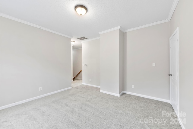 spare room with a textured ceiling, light colored carpet, and crown molding