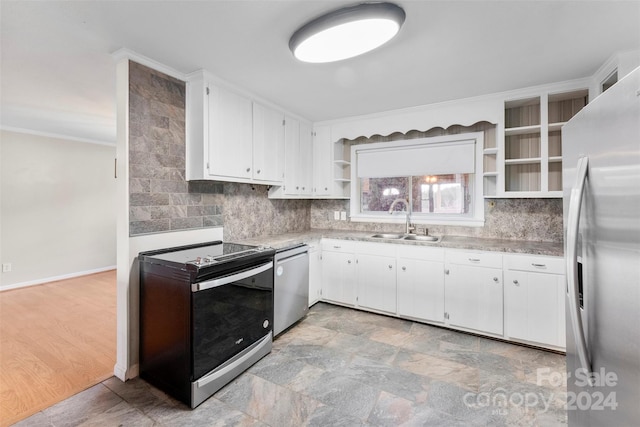 kitchen with appliances with stainless steel finishes, backsplash, white cabinetry, and sink