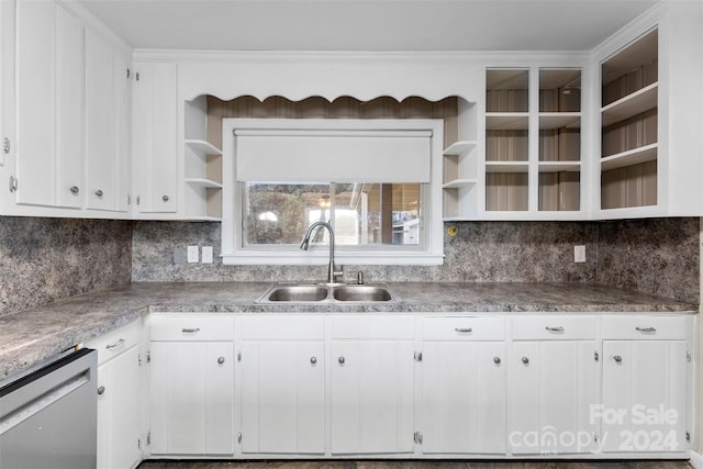 kitchen with stainless steel dishwasher, backsplash, white cabinetry, and sink