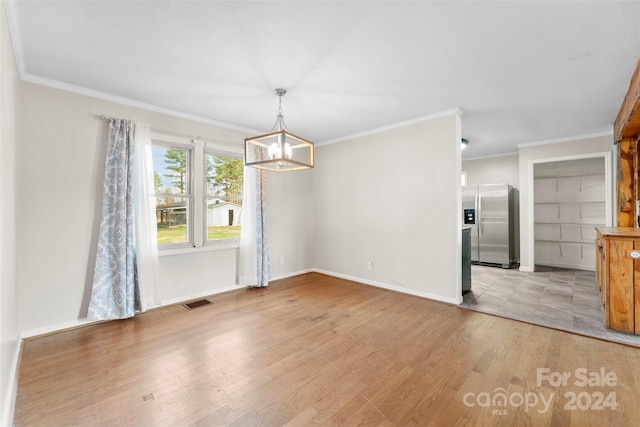 unfurnished dining area with a chandelier, light hardwood / wood-style floors, and ornamental molding