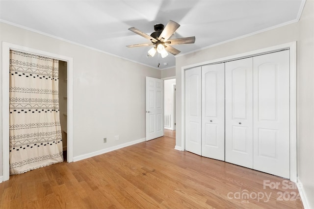 unfurnished bedroom with ceiling fan, light wood-type flooring, ornamental molding, and a closet