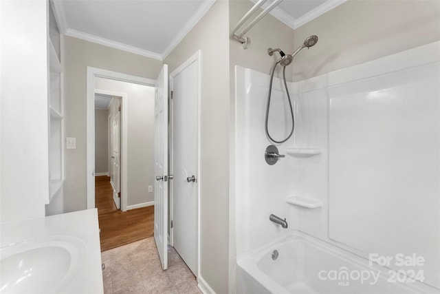 bathroom with hardwood / wood-style floors, vanity, tub / shower combination, and crown molding