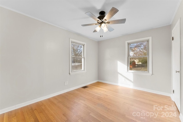 spare room featuring light hardwood / wood-style floors, plenty of natural light, crown molding, and ceiling fan