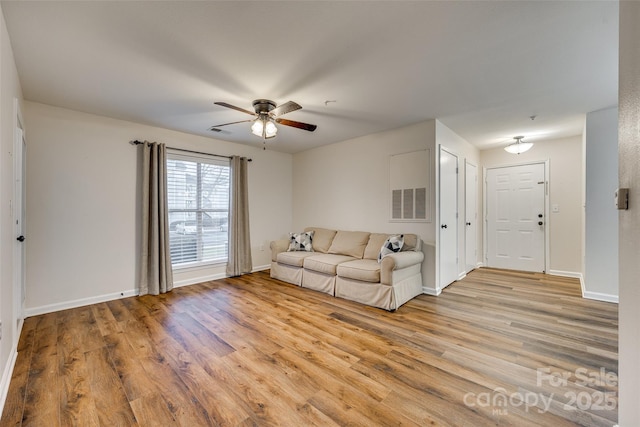 living room with light hardwood / wood-style floors and ceiling fan