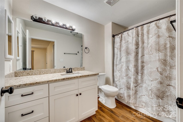 bathroom with wood-type flooring, vanity, and toilet