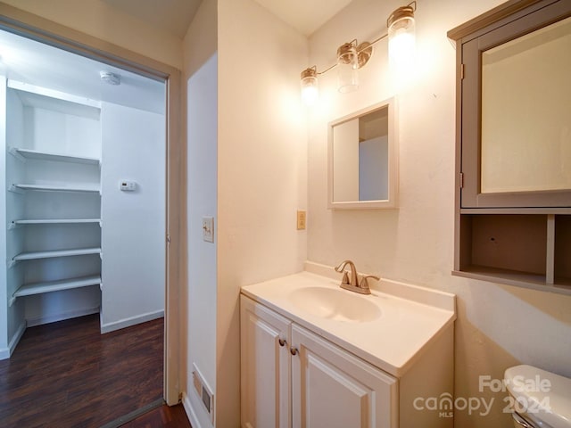 bathroom with vanity, hardwood / wood-style flooring, and toilet