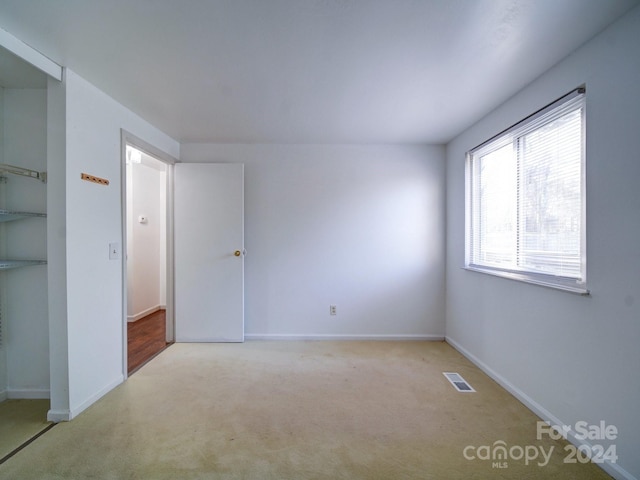 unfurnished room featuring light colored carpet