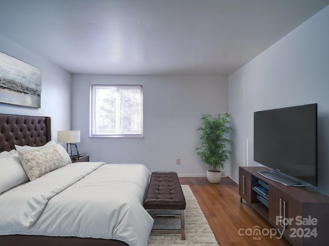 bedroom with dark hardwood / wood-style flooring