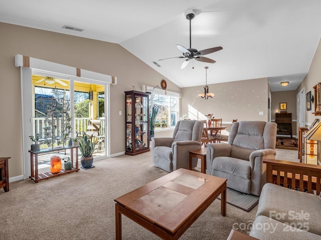 carpeted living room with a healthy amount of sunlight, a chandelier, and lofted ceiling