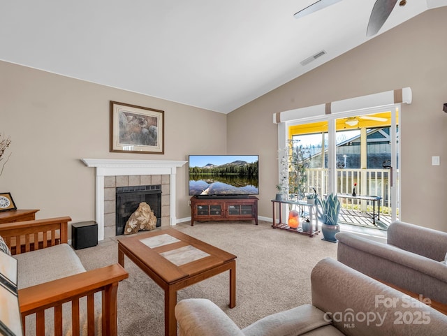 living room featuring ceiling fan, lofted ceiling, a fireplace, and carpet floors